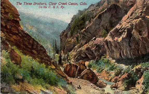 Hand-tinted postcard shows a narrow canyon with red rock walls.  Title labels it "The Three Brothers"