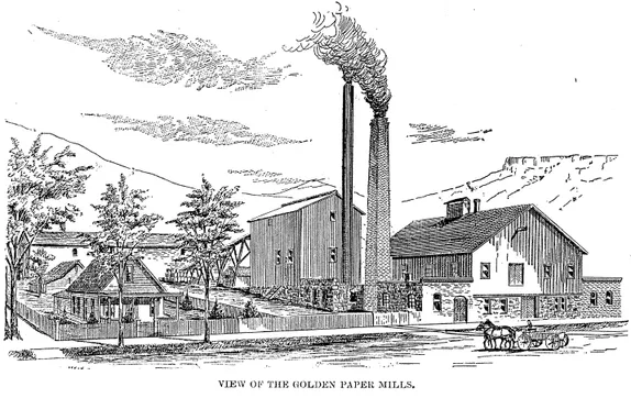 Two 2-story industrial buildings with two smokestacks,a small cottage in a fenced yard next door, and team and wagon in front