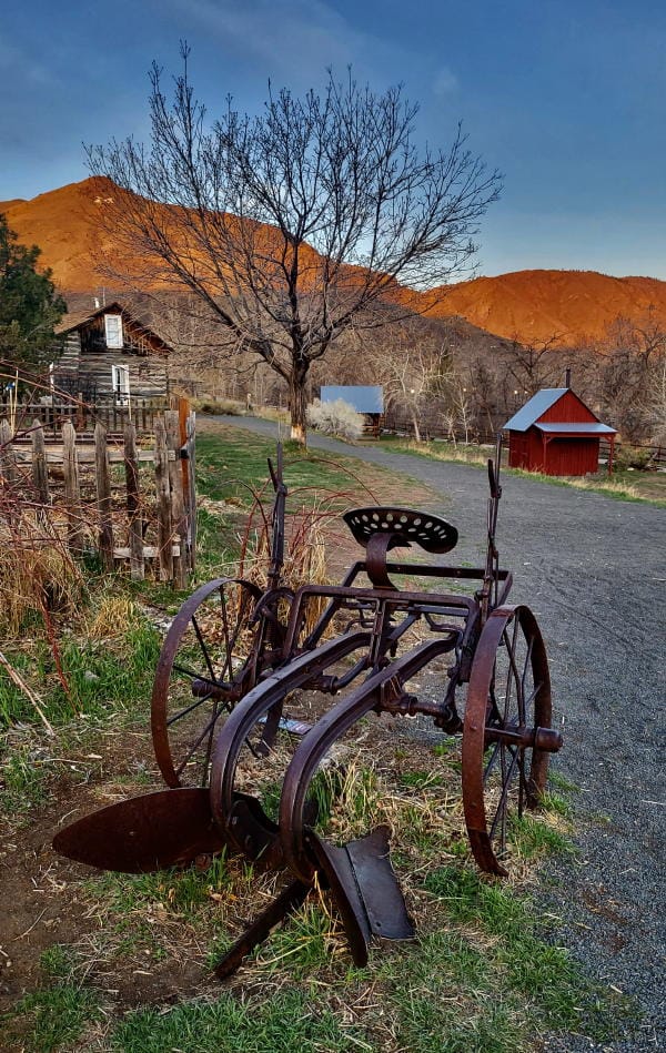 Antique plow in the Clear Creek History Park with the Sunrise Gilding the Mountains to the West