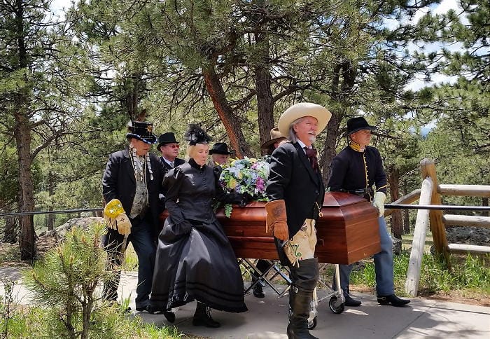 A group in historical costume deliver a coffin to Buffalo Bill's grave.