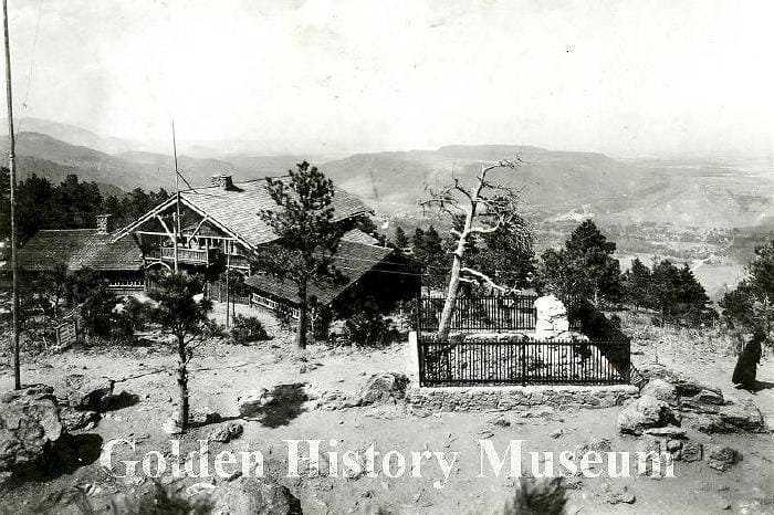 Buffalo Bill's grave, surrounded by a fence, with Pahaska Teepee (the Buffalo Bill Museum) in the background