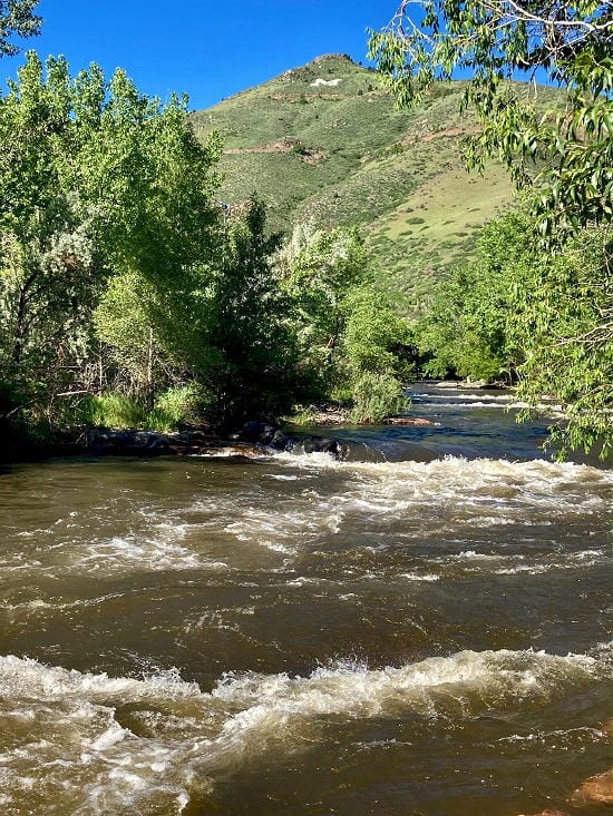 Clear Creek running very high, water brown with white caps.  Mount Zion in the background.