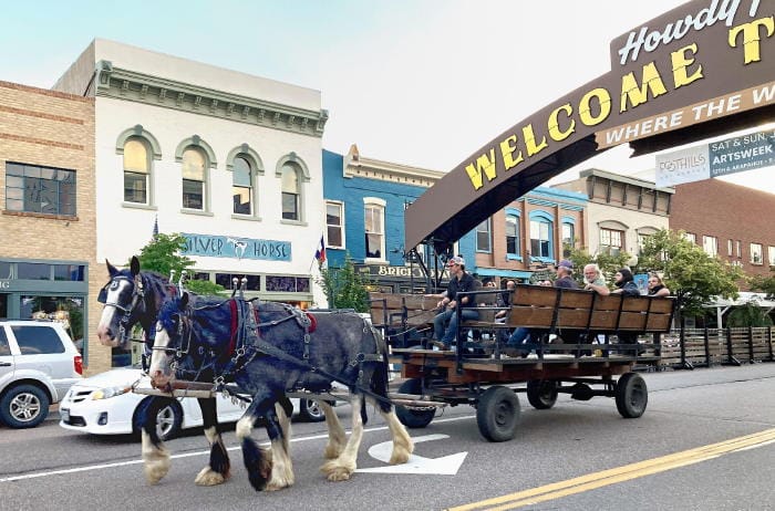 A team of Clydesdales pulling a wagon through downtown Golden Colorado