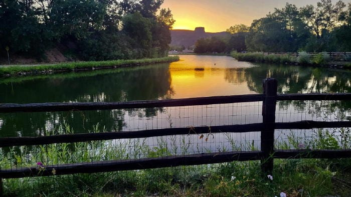 Sun coming up behind South Table Mountain - pond in the foreground.