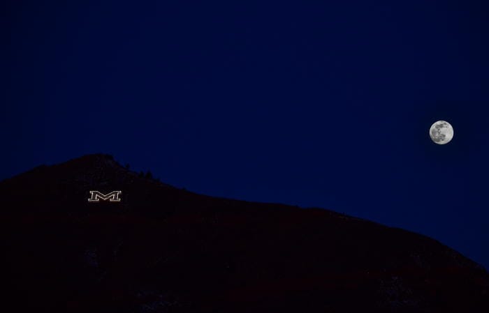 Full moon setting behind Mt. Zion in Golden Colorado.  The illuminated M stands for the Colorado School of Mines.