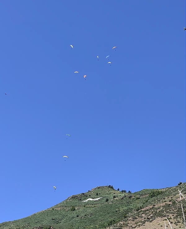 Eleven hang gliders hovering over the M on Mt. Zion