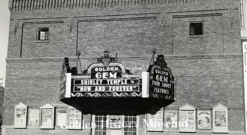 movie marquee on a 2-story brick building advertising Shirley Temple in Now and Forever