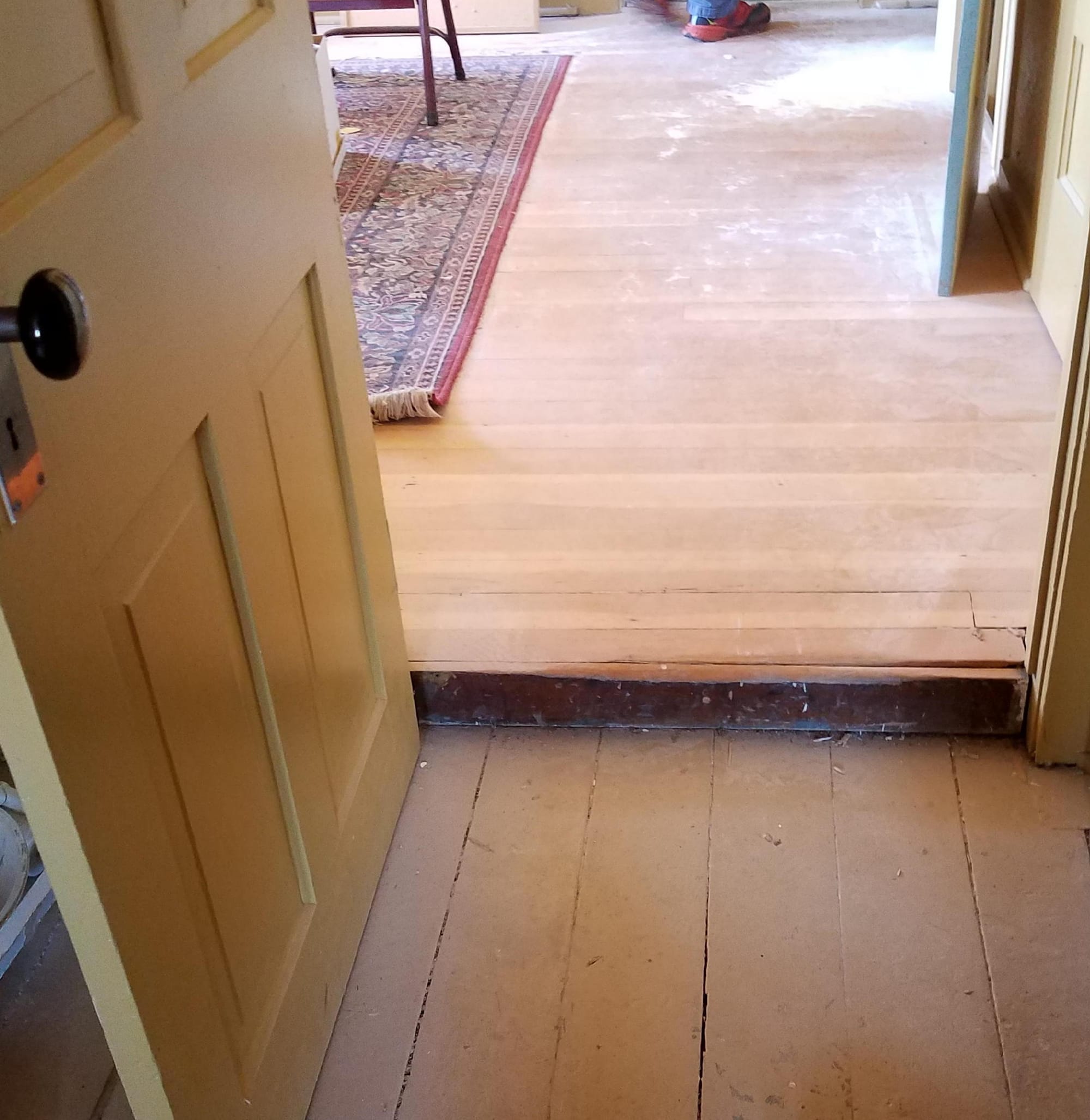 doorway showing a 2 inch difference in height of the board floors