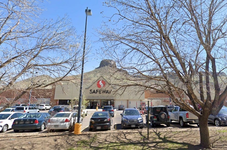 modern Safeway store with cars parked in front and Castle Rock in the background