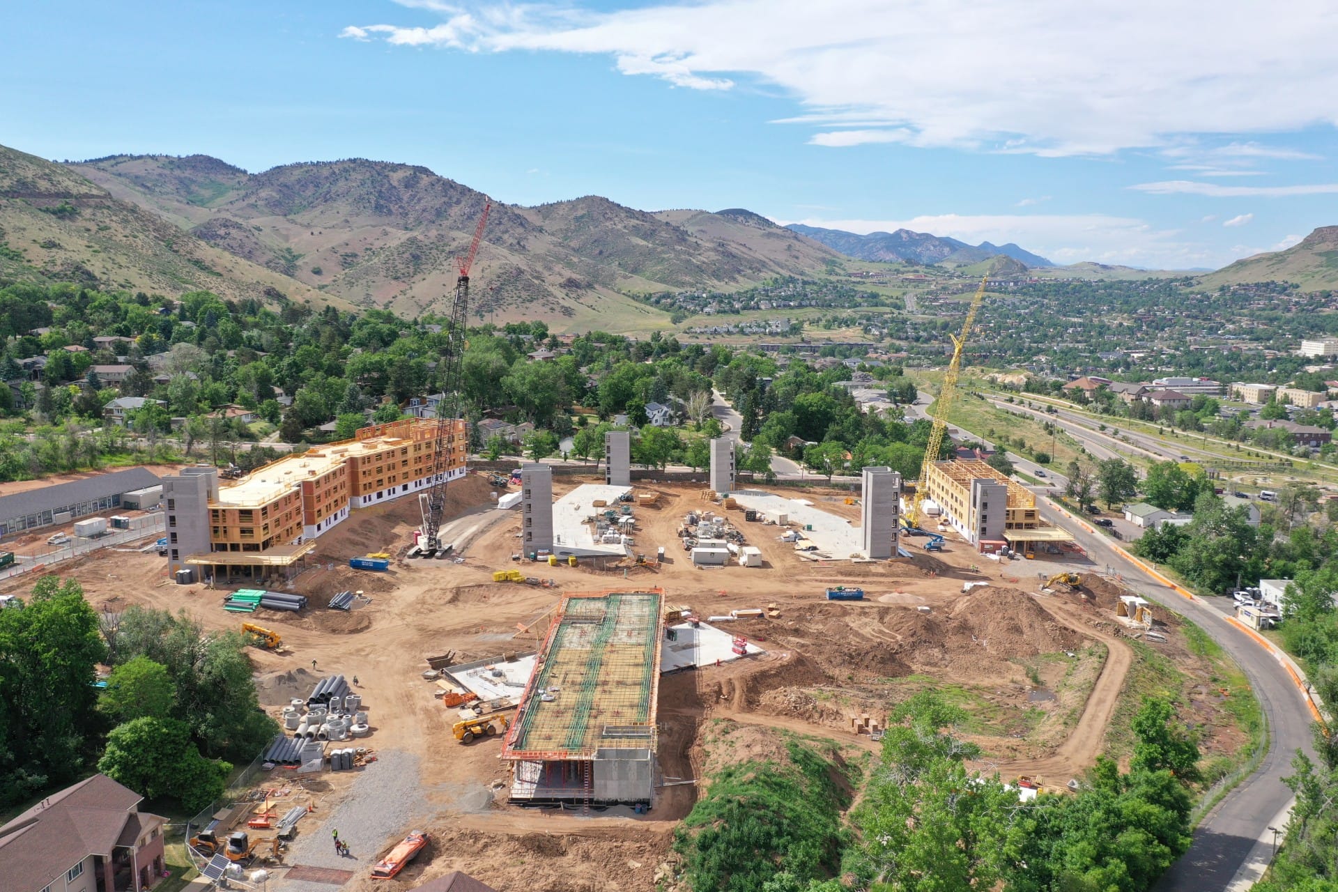 Construction underway in mines park, with several concrete elevation shaft and two cranes at buildings being framed