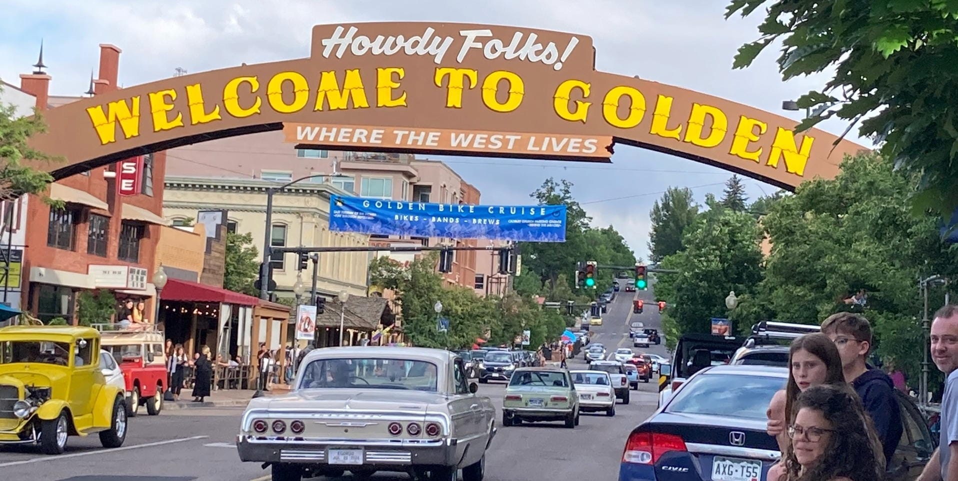 64 Chevy under the welcome arch - yellow jalopy in the opposite lane