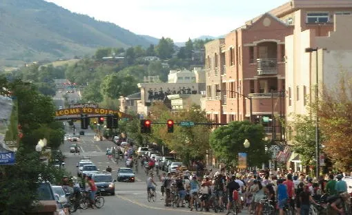 group of bicyclists heading north on Washington Avenue - arch in the distance, mountains in background