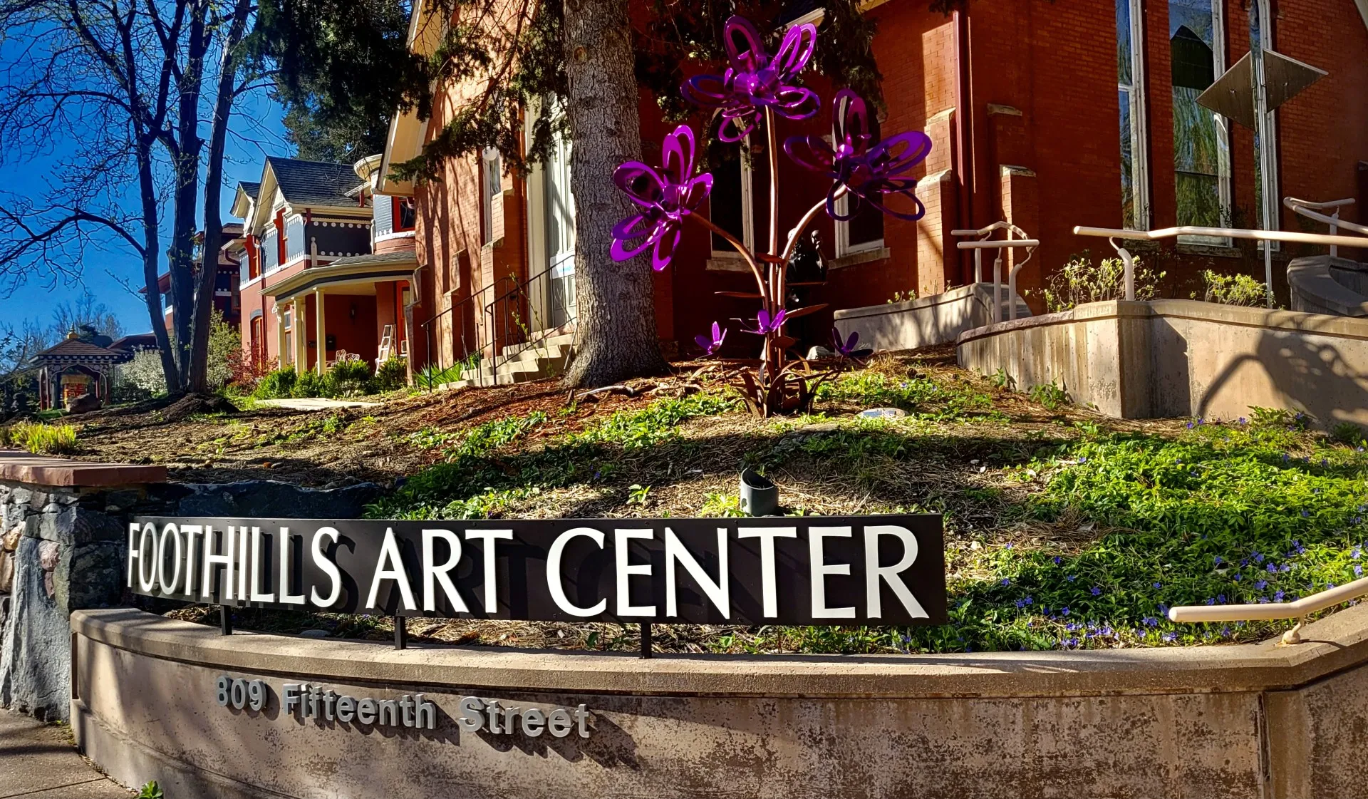 closeup of the "Foothills Art Center" sign with red brick buildng in the background