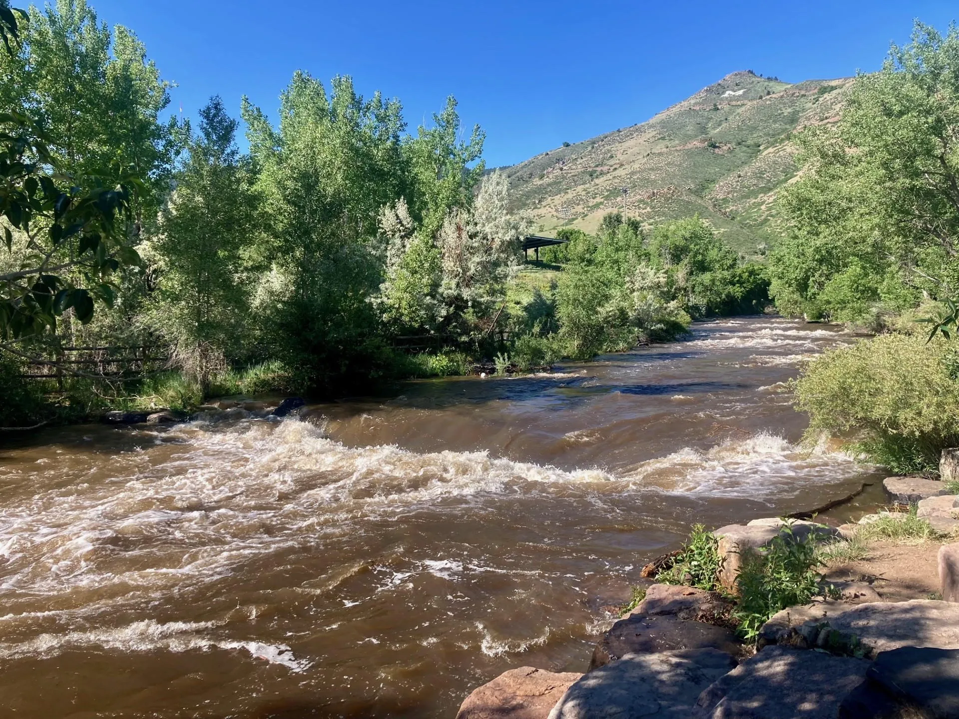 Clear Creek running very fast and high, with the water churned to a dark brown