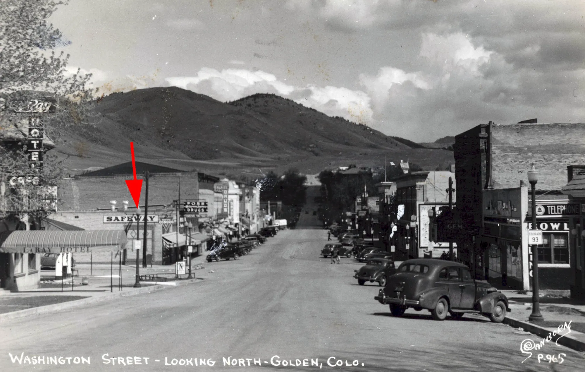 black and white postcard view of Washington Avenue, facing north, with a red arrow pointing to the Safeway store