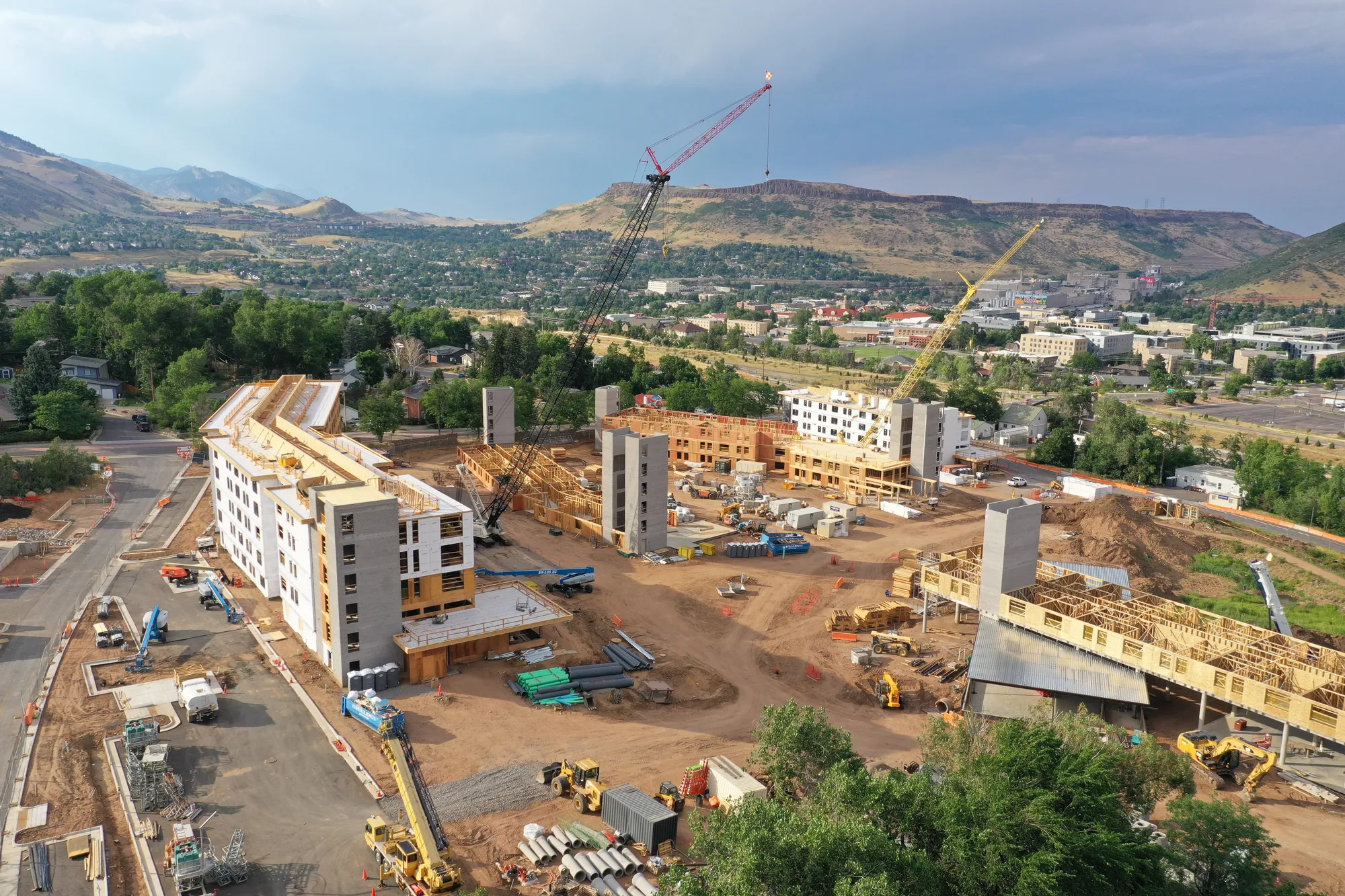 several cranes working on multi-story buildings - North Table Mountain in the background