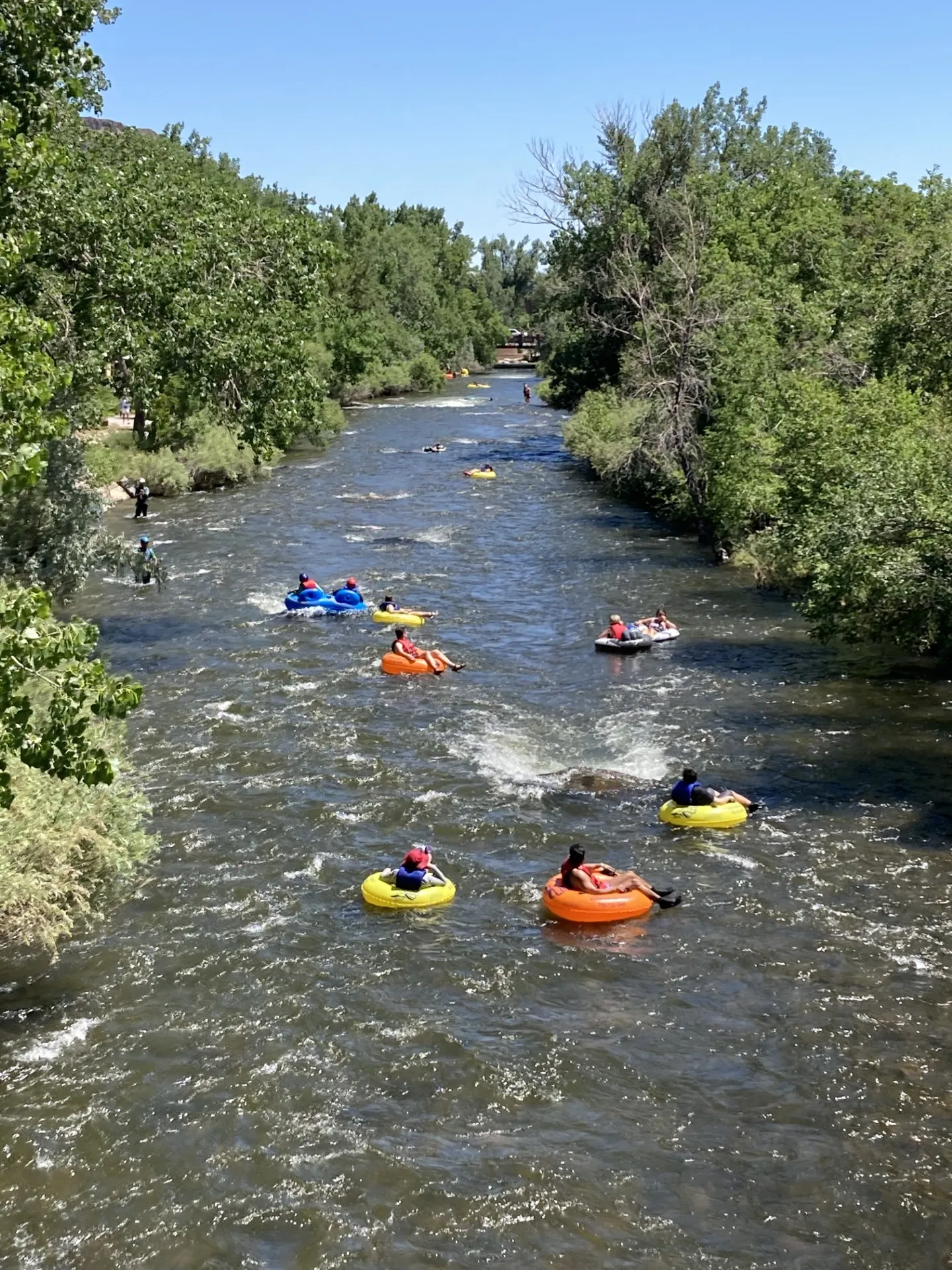 view east along Clear Creek with several tubers floating down the current