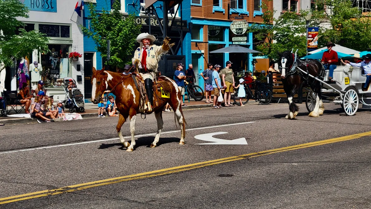 Buffalo Bill on a paint gelding (Sonny), followed by a Clydesdale (Wallace) pulling a white carriage