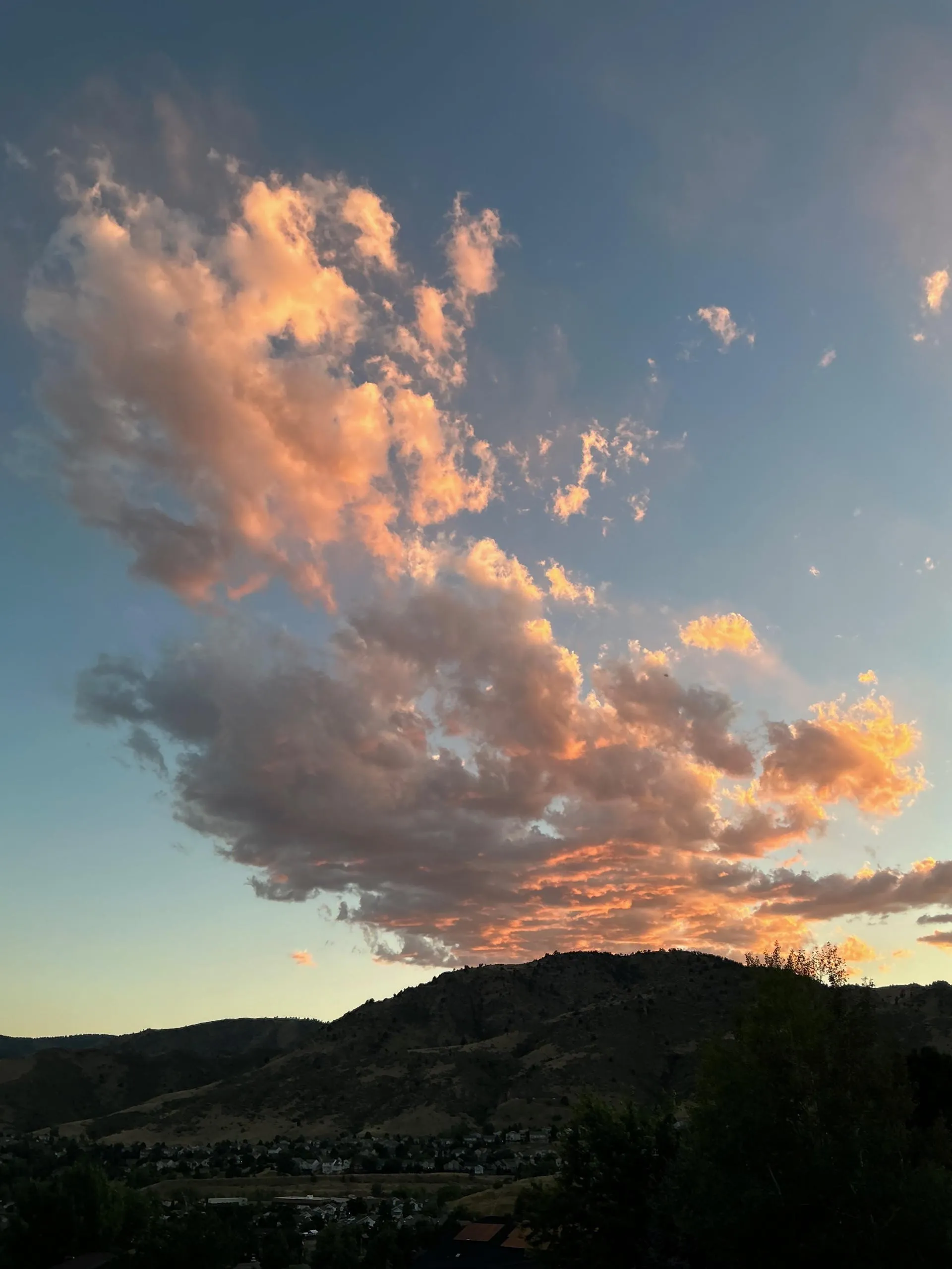 sun setting behind the mountains, leaving fiery clouds