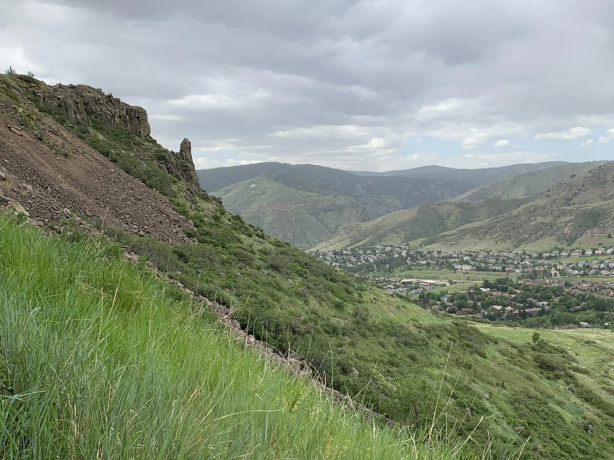 steep slope of North Table Mountain in the foreground, front range and houses in the distance