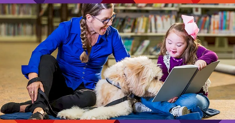 child reading a book to a big, fluffy dog