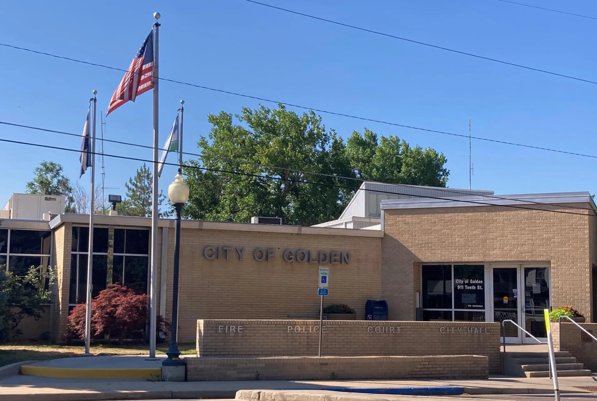 Golden's city hall: brick building with 3 flags in front