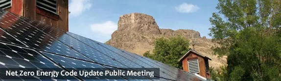 A roof with solar panels with Castle Rock in the background