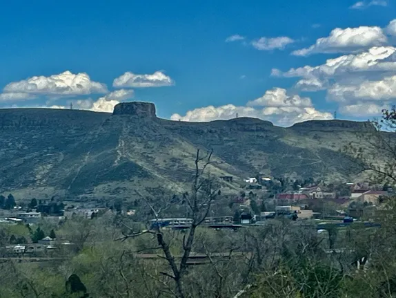 Castle Rock seen from the entrance to Clear Creek Canyon.  Tree tops in foreground starting to bud.