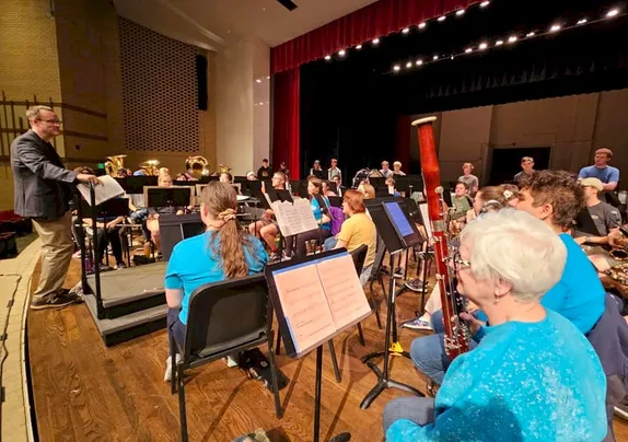 all-ages orchestra facing a conductor at a podium