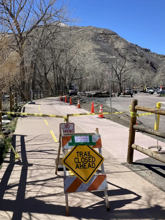 yellow tape and a sign saying Trail Closed Ahead" block entrance to the Clear Creek trail
