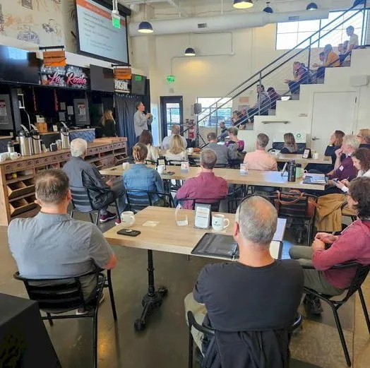 People in a restaurant looking at a speaker in front of the room