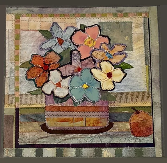 picture of flowers in a basket composed of pieces of colored paper, zig-zag stitiched together