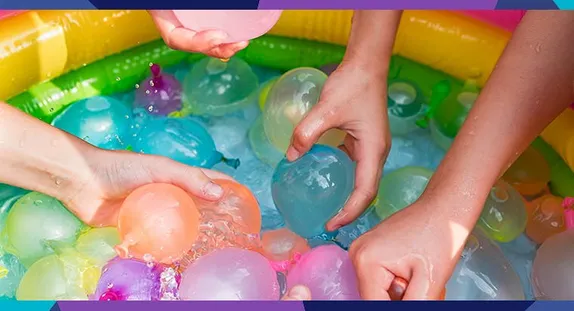 hands filling water balloons in a wading pool
