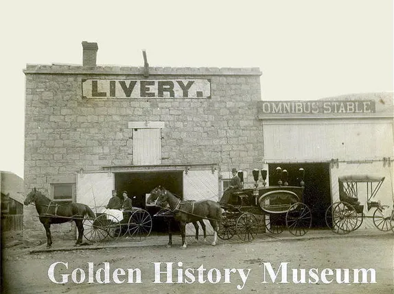 stonelivery stable with horse hitched to buggy, team hitched to Hearse, and a two seat buggy unhitched