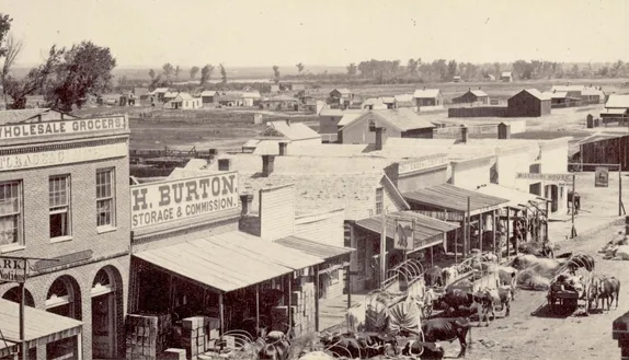 Blake Street Denver in 1860 - several 1 story wooden building, horses hitched to wagons