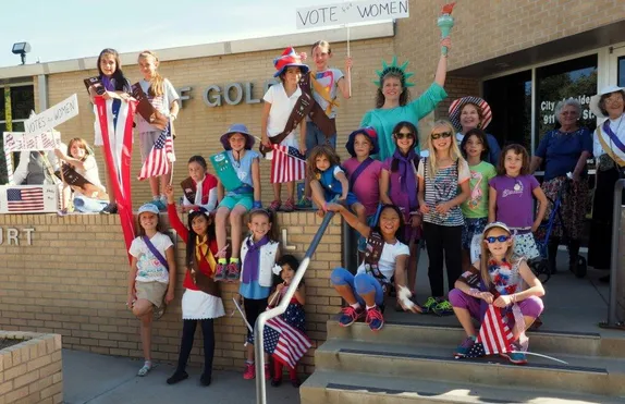 group of Brownies & Girl Scouts with a woman in a Statue of Liberty costume at Golden City Hall